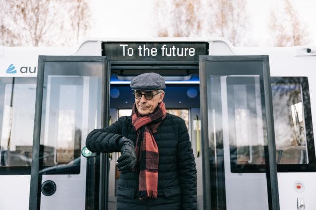 Man Standing in Front of Self Driving Bus